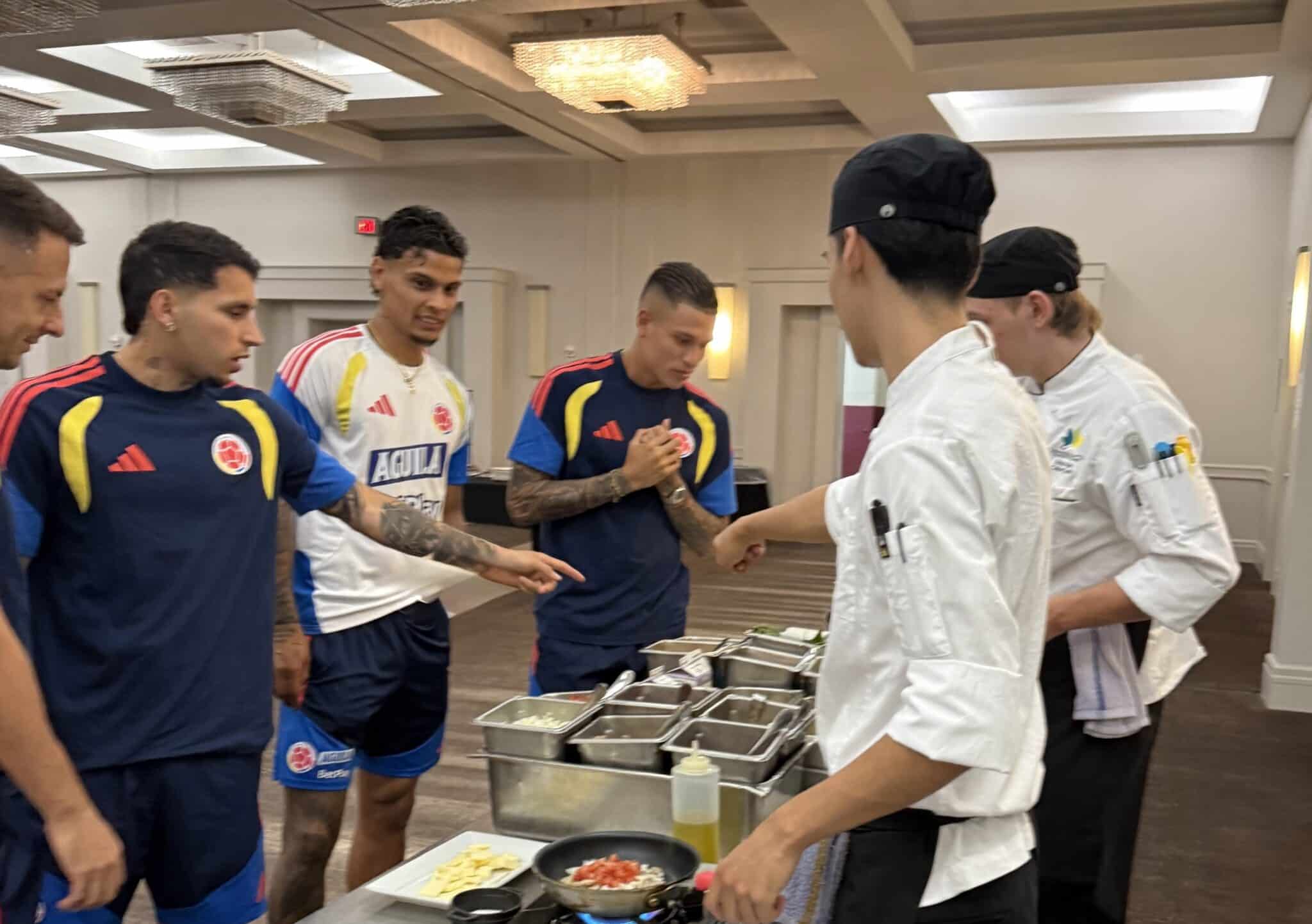 Two culinary students serving four soccer players in a buffet line